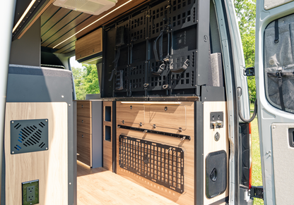 Utility cabinet close-up with air vent and power outlet integrated into Highland Vans Murphy Bed System design