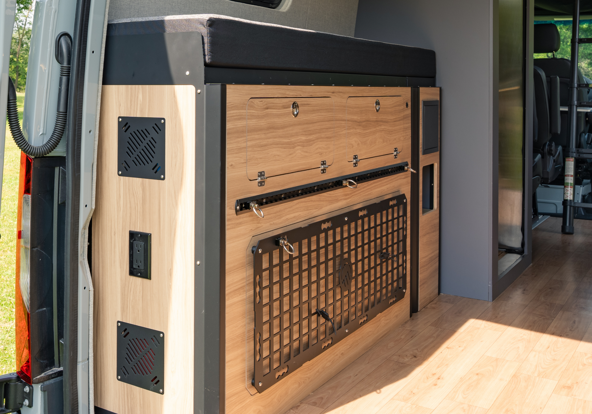 Side view of Murphy Bed System in Sprinter van by Highland Vans, showing ventilation panels and outlet ports